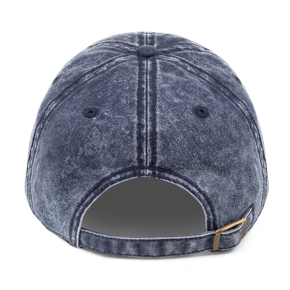 Back of the navy vintage cap showing the adjustable antique-brass buckle