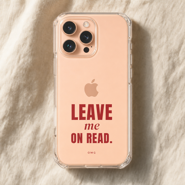 Clear iPhone case printed “Leave me on read.” in deep red, on a peach iPhone lying on cream linen