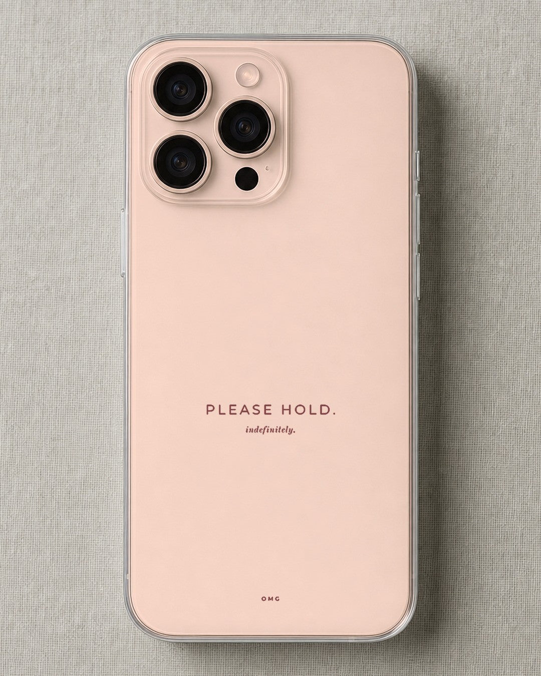 Clear iPhone case printed “Please hold, indefinitely” in dark rose lettering